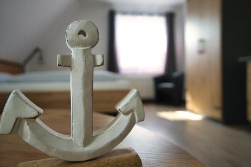 a wooden anchor on the floor of a room at Meerzeit Strandhotel in Neuharlingersiel