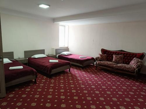 una habitación de hotel con dos camas y un sofá en DDHotel, en Almaty