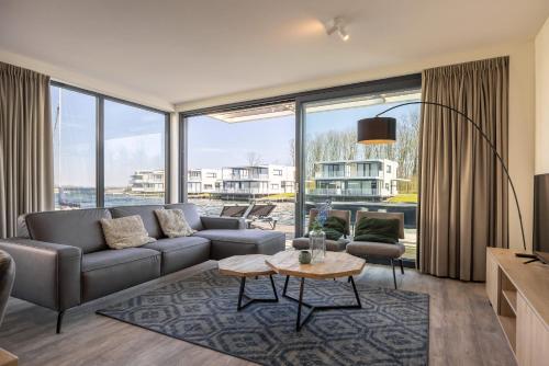 a living room with a couch and a table at Hello Zeeland - Water Villa's Veerse Wende - with dog in Arnemuiden