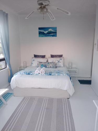 a bedroom with a bed and a ceiling fan at Bayview Guest House in Amanzimtoti