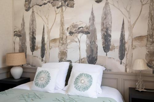 a bedroom with a bed with white pillows at Domaine de Saint-Saturnin in Morvillers-Saint-Saturnin