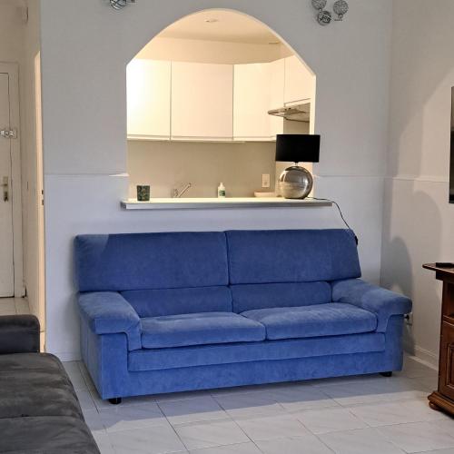 - un canapé bleu dans le salon avec une arche dans l'établissement Spacious Apartment - High Standing Residence, à Cannes