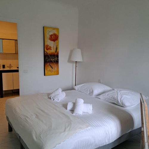 - un lit blanc avec des serviettes dans la chambre dans l'établissement Spacious Apartment - High Standing Residence, à Cannes