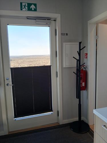 a door with a window with a view of the beach at Pálína Cottage studio in Selfoss
