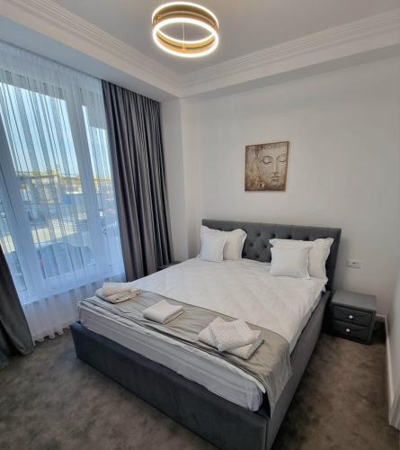 a bedroom with a large bed with a large window at Gonbuilding Residence in Suceava