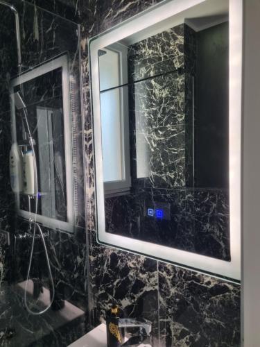 a bathroom with two mirrors and a sink at Gonbuilding Residence in Suceava