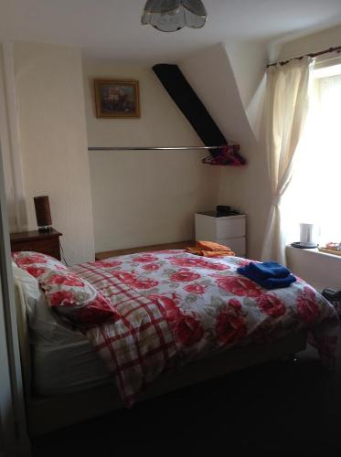 um quarto com uma cama com uma colcha vermelha e branca em The Beaufort Hunt em Chipping Sodbury