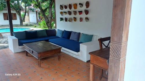 a living room with a blue couch and a table at Si Pitung Village in Gili Air