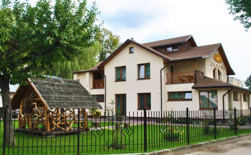 a house with a playground in front of a fence at Žemyna Apartmentai in Druskininkai
