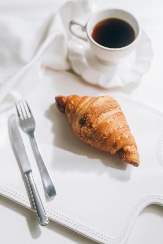 ein Croissant und eine Tasse Kaffee auf dem Tisch in der Unterkunft Just be holidays France in Saint-Gouéno