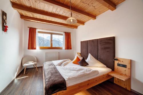 Un dormitorio con una cama grande con cabecero de madera. en Bergbauernhof Zeppenhof, en Santa Valpurga