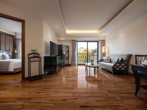 a hotel room with a bed and a living room at Elegant Suites Westlake in Hanoi