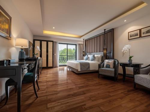 a bedroom with a bed and a desk at Elegant Suites Westlake in Hanoi