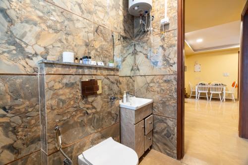 baño con aseo y pared de piedra en Homlee-Legacy 3BHK Flat in Central DEL-Lift-Terrace, en Nueva Delhi