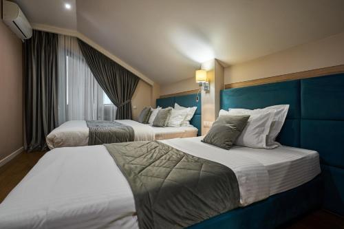two beds in a hotel room with blue walls at F&B Spa Resort (ex. Fomich Hotel) in Bukovel
