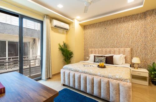 Un dormitorio con una cama grande y un balcón. en Homlee-Legacy 3BHK Flat in Central DEL-Lift-Terrace, en Nueva Delhi