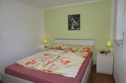 a bedroom with a bed with a floral bedspread at Ferienwohnung Am alten Holzweg in Endlichhofen