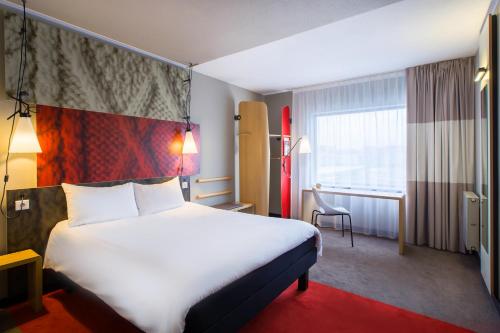 a hotel room with a large bed and a window at Ibis Wroclaw Centrum in Wrocław