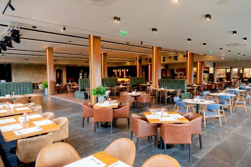 a dining room with tables and chairs and tablesktop at Grand Hotel Bansko - Fitness & SPA in Bansko