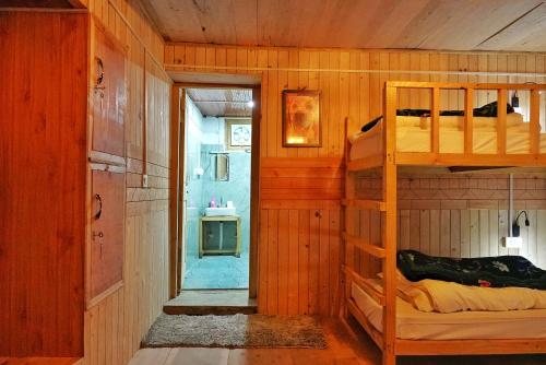 a bedroom with bunk beds in a wooden room at Ailyak Stays Seri in Jibhi