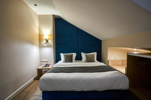 a bedroom with a large bed with a blue headboard at F&B Spa Resort (ex. Fomich Hotel) in Bukovel