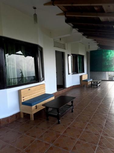 a room with two benches and a table at Dolia Pahadi Myar Maiti in Rānīkhet
