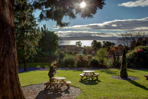 a man standing in a park with two picnic tables at Invercarse Hotel Dundee, BW Signature Collection in Dundee
