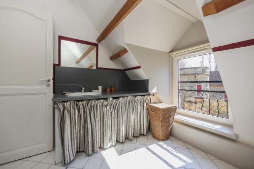 a bathroom with a sink and a window at La Demeure de la Poterie, Wimille & Wimereux in Wimille