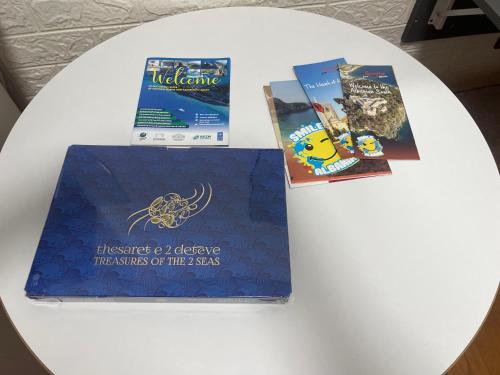 three books sitting on top of a white table at Villa Roel 2 -apartments in Vlorë