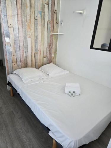 - un lit avec 2 serviettes blanches dans l'établissement Escapade ensoleillée Cocon T1, à Ajaccio