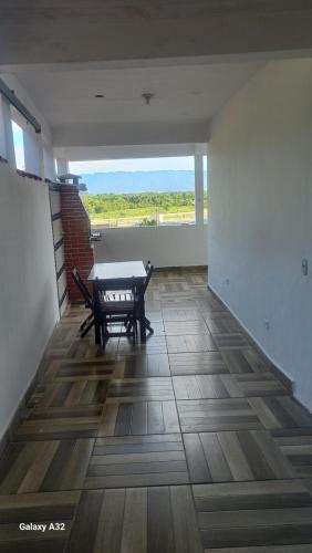 a empty room with a table and a bench in it at Cantinho Caiçara in São Sebastião