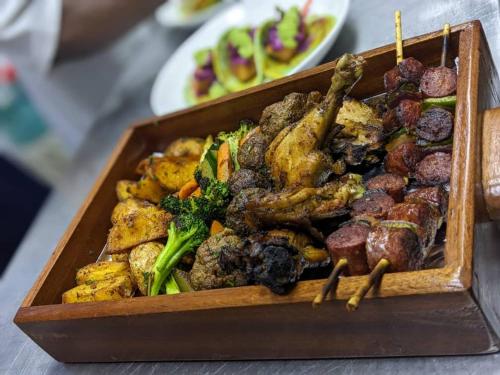 a tray of food with meat and vegetables on sticks at Saphir Boutique Hotel in Kigali