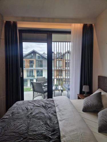 a bedroom with a bed and a view of a balcony at Apartament Moja Magdalenka in Zarzecze