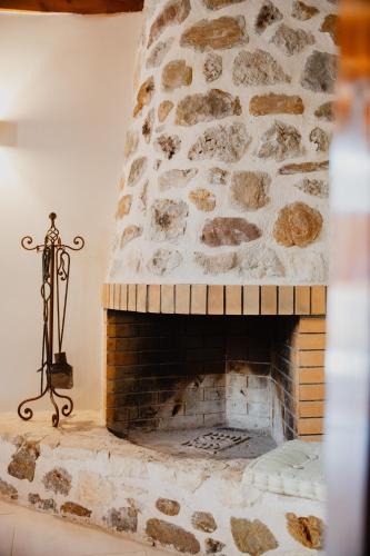 a stone fireplace with a statue next to it at Domus Polymnia, hospitality at its best! in Spílion