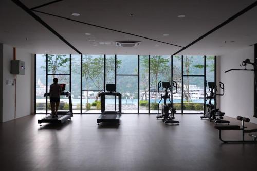 a gym with several people exercising on tread machines at SunshineResidence 5pax Near Georgetown in Ayer Itam