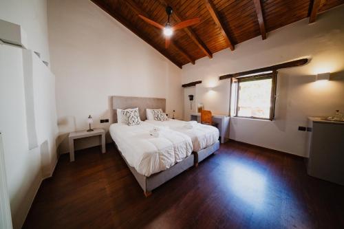 a bedroom with a white bed and a window at Domus Polymnia, hospitality at its best! in Spílion