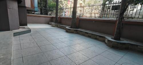 a walkway with a balcony with a palm tree at TIM Service Apartment Goregaon East Near NESCO in Mumbai