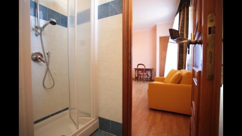 a bathroom with a shower and a yellow couch at Residenza Matilde in Rome