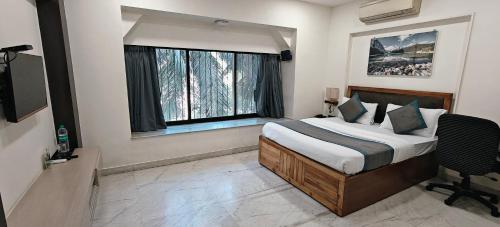a bedroom with a bed and a large window at TIM Service Apartment Goregaon East Near NESCO in Mumbai