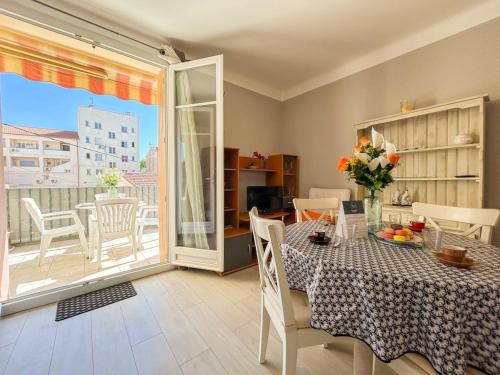 une salle à manger avec une table et un balcon dans l'établissement T2 sur le port de Sanary avec garage, à Sanary-sur-Mer