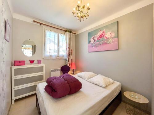 une personne assise sur un lit dans une chambre dans l'établissement T2 sur le port de Sanary avec garage, à Sanary-sur-Mer