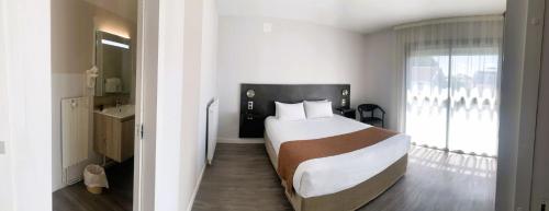 a bedroom with a large bed and a window at Grand Hotel in Dax