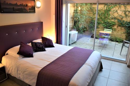 een slaapkamer met een bed met paarse kussens erop bij Villa Etoile Cannes in Cannes