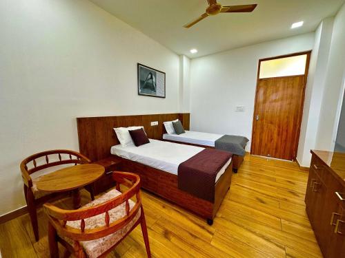 a bedroom with a bed and a table and a chair at Kala Retreat in Rishīkesh