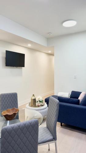 a living room with a blue couch and a tv at Bright Luxurious 2 Bedroom Apartment in Toronto