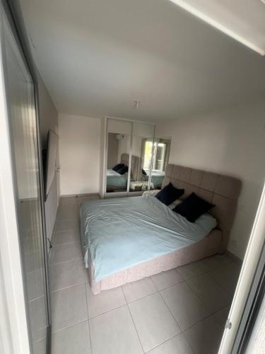 une chambre avec un grand lit et un miroir dans l'établissement Villeneuve-Loubet Appartement, à Villeneuve-Loubet