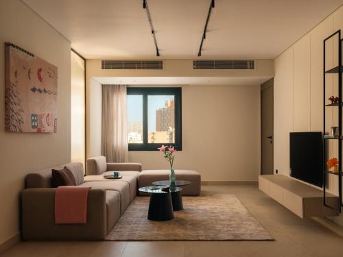 a living room with a couch and a tv at Brassbell Zamalek Diplomatic Zone Near Marriott in Cairo
