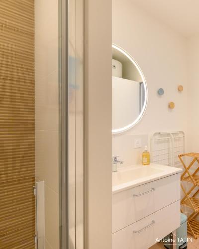 une salle de bain avec un lavabo et un miroir dans l'établissement Barbâtre - Les Figuiers, à Barbâtre