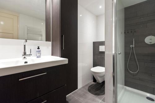 a bathroom with a sink and a toilet and a shower at Garden House Harry in Zandvoort