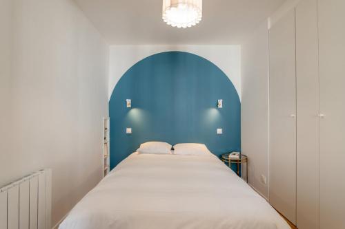 - un grand lit dans une chambre dotée d'un mur bleu dans l'établissement Cozy Faubourg St Martin retreat, à Paris